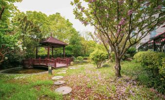 A small gazebo surrounded by trees and shrubs is located in the middle at Ramada Plaza by Wyndham Shanghai Pudong Airport