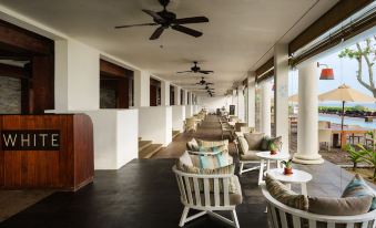 a long hallway with several chairs and couches lined up along the walls , creating a cozy and inviting atmosphere at The Fortress Resort & Spa