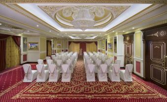 a large , ornate room with a red and gold carpet has rows of chairs arranged in a row at Royal Rose Abu Dhabi, a Curio Collection by Hilton Affiliated Hotel