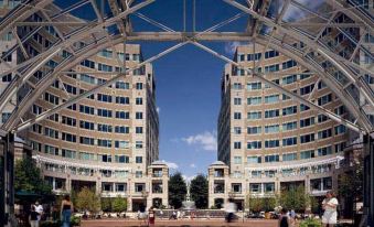 a large open courtyard with people walking around , surrounded by buildings and a blue sky at Courtyard Fairfax Fair Oaks