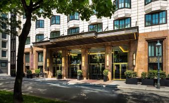 a brick building with a large tree in front of it , creating a picturesque scene at Hilton Vienna Plaza