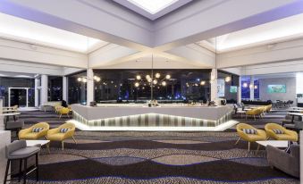 a modern hotel lobby with a white reception desk and multiple chairs , creating an inviting atmosphere at Sea World Resort