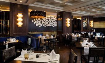 a large dining room with multiple tables and chairs , some of which are occupied by people at Hilton Vienna Plaza