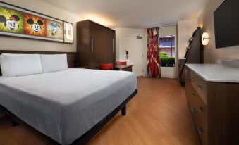 a modern hotel room with a large bed , wooden floors , and a view of the city through a window at Disney's All-Star Music Resort