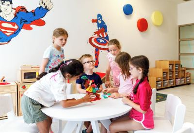 a group of children are gathered around a table in a classroom , playing with legos and having a fun time together at Ikos Dassia Ikos Dassia - All Inclusive Photo