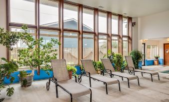 a row of white lounge chairs is lined up in front of a large window at Adobe Resort