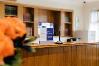 "a wooden reception desk with a potted plant and a sign that reads "" welcome "" on it" at Best Western Bradford Guide Post Hotel Best Western Bradford Guide Post Hotel Photo