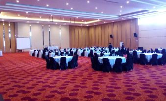 a large banquet hall with tables and chairs set up for a formal event , possibly a wedding reception at Novena Hotel Bandung