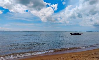 a beautiful beach scene with a boat floating in the ocean , surrounded by sand and blue water at Kampong Pinang Sebatang