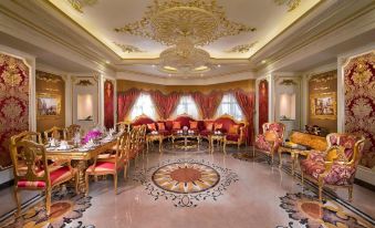 a large dining room with red and gold decor , including chairs , tables , and a central table at Royal Rose Abu Dhabi, a Curio Collection by Hilton Affiliated Hotel