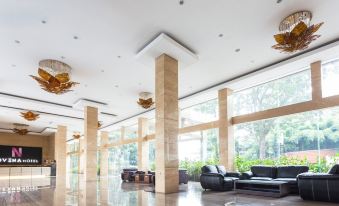 a large , well - lit lobby with high ceilings , high - ceilings , and large windows , as well as comfortable seating arrangements at Novena Hotel Bandung