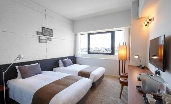 a modern hotel room with two beds , a window , and a desk , decorated in white and brown colors at Kawasaki King Skyfront Tokyu Rei Hotel