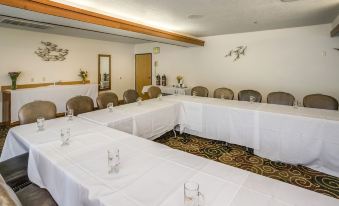 a large conference room with multiple white tables and chairs , set up for meetings or events at Adobe Resort