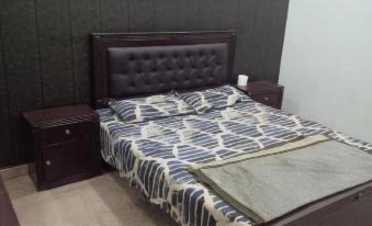 a bed with a black headboard and footboard , covered in a blue and white striped comforter at Parkway Apartments