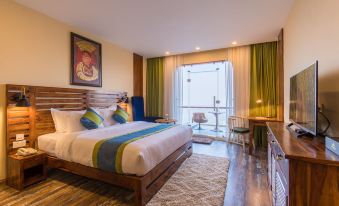 a large bed with white linens and a wooden headboard is in the middle of a room at Aagantuk Resort