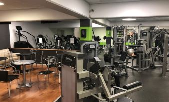 a well - equipped gym with various exercise equipment , including weights and treadmills , in a spacious room at Best Western Plus Airport Hotel Copenhagen