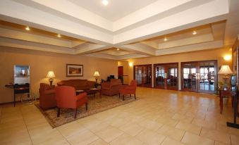 a large , well - lit hotel lobby with multiple couches and chairs arranged for guests to sit and relax at Franklin Inn and Suites