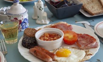 a plate of breakfast food , including bacon , eggs , sausage , and toast , is displayed on a table at The Waterfront