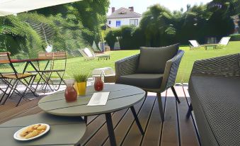 a patio area with a table and chairs set up for outdoor dining , surrounded by a lush green lawn at Republique