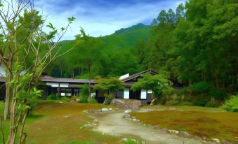 a serene scene of a wooden house nestled in a green environment , surrounded by lush trees and grass at Ryugon