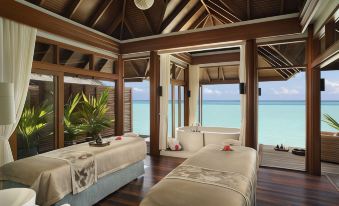 a luxurious beach - side resort with two beds , a bathtub , and a view of the ocean at Anantara Dhigu Maldives Resort