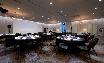 a large dining room with round tables and chairs set up for a formal event at voco MANCHESTER - CITY CENTRE