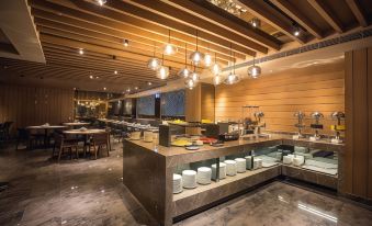 a modern restaurant with wooden ceiling , marble floors , and large windows , featuring a dining area with tables , chairs , and a buffet table filled at Airline Inn Kaohsiung Station