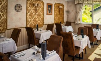 a dining room with tables and chairs arranged for a group of people to enjoy a meal together at Woodlands