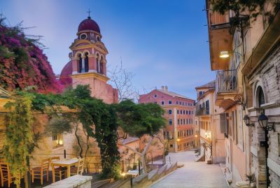 a quaint european town with a red brick church at its center , surrounded by old buildings at Ikos Dassia Ikos Dassia - All Inclusive Photo