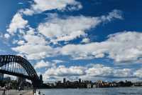 Sydney Opera House, Harbour Bridge, and clouds.