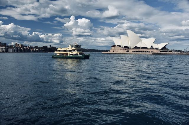 Sydney Opera House, Harbour Bridge, and clouds.