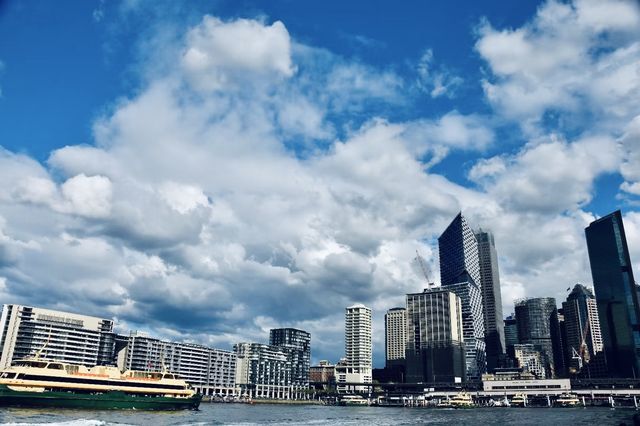 Sydney Opera House, Harbour Bridge, and clouds.