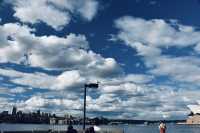 Sydney Opera House, Harbour Bridge, and clouds.