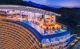 At night, there is a large building with a pool and a hotel in the background, offering an elevated view at Chimelong Spaceship Hotel