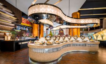 The restaurant features a spacious layout with a wide variety of food options displayed on the counter at Jianguo Hotel, Guangzhou