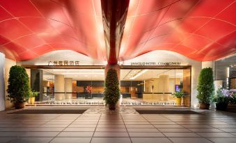 The entrance to a spacious building features an illuminated ceiling and glass panels on either side at Jianguo Hotel, Guangzhou