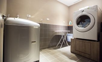 a laundry room with a washing machine , a dryer , and a sink , all situated in a modern space at Airline Inn Kaohsiung Station