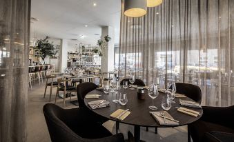 a modern restaurant with a black table , wine glasses , and wine bottles on the tables at Best Western Plus Airport Hotel Copenhagen