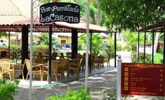 "an outdoor restaurant with a sign that reads "" bar parrillada lacasna "" on the awning , surrounded by tables and chairs" at Hostal la Casona