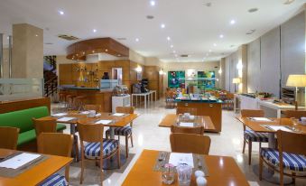 a large dining room with multiple tables and chairs arranged for a group of people to enjoy a meal together at NH San Pedro