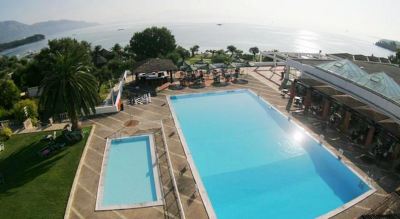 an aerial view of a large outdoor pool surrounded by chairs and tables , with a view of the ocean in the background at Ikos Dassia Ikos Dassia - All Inclusive Photo