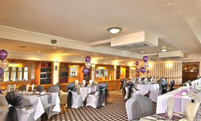 a banquet hall with tables and chairs , decorated with purple and silver balloons , creating a festive atmosphere at Best Western Bradford Guide Post Hotel Best Western Bradford Guide Post Hotel Photo