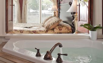 a luxurious bedroom with a large bathtub in the middle of the room , surrounded by various furniture and decorations at Colonial Inn