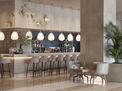 a modern bar with various seating options , including chairs and stools , as well as a dining table at Ikos Dassia Ikos Dassia - All Inclusive Photo