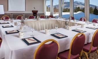 a conference room set up for a meeting with tables and chairs arranged in a semicircle at White Mountain Hotel and Resort