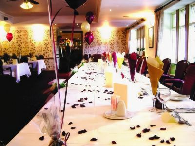 a long dining table set up for a formal event , with balloons and confetti scattered on the floor at Best Western Bradford Guide Post Hotel Best Western Bradford Guide Post Hotel Photo