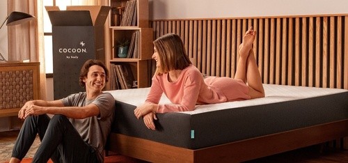 Woman talking to man while laying on cocoon mattress