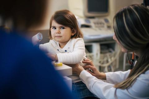 Female child being examined by healthcare provider in medical office