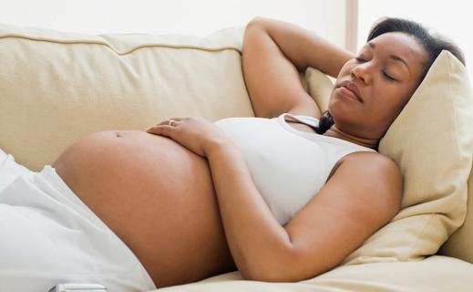 Pregnant person sleeping on back on the couch