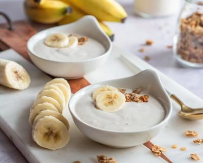 Two bowls of banana mouse on a tray with slices of banana